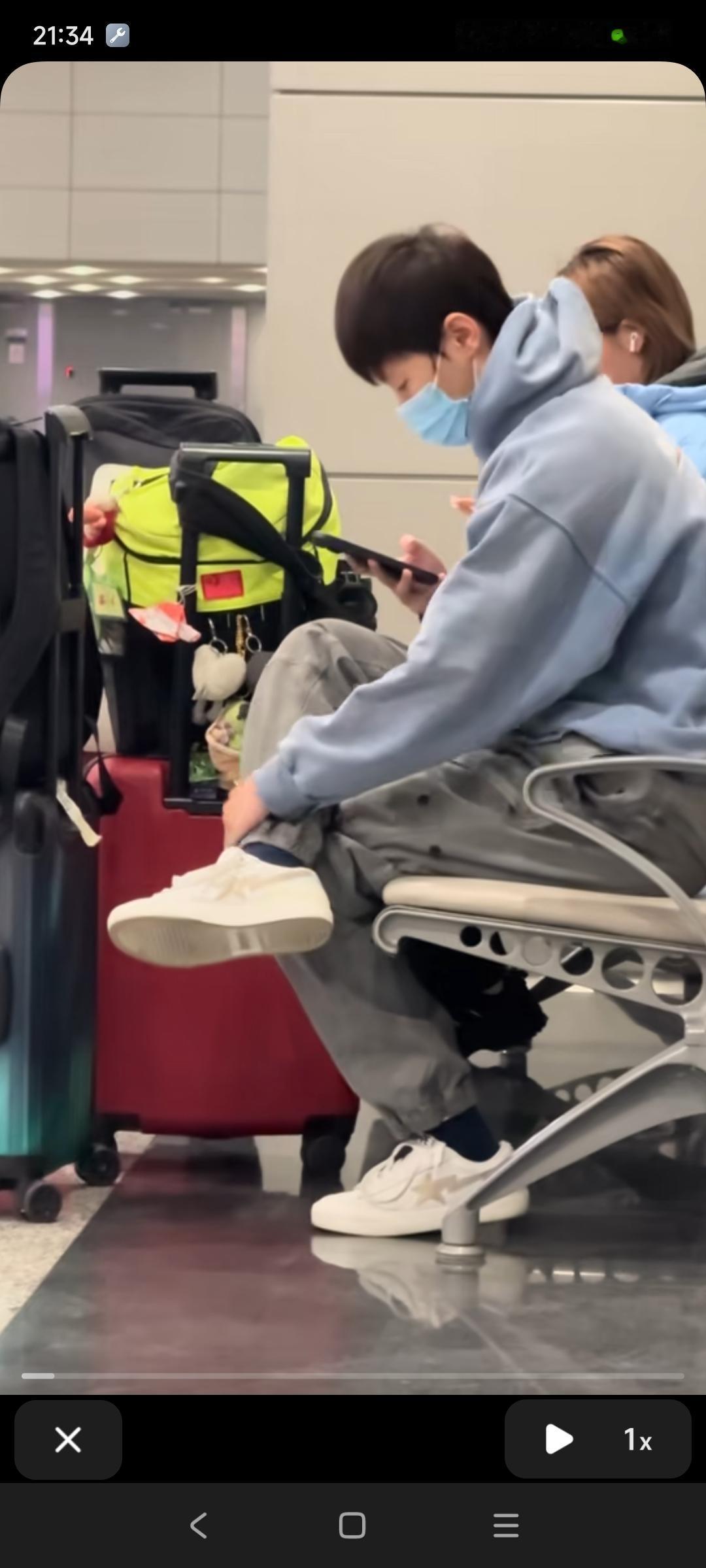 到达成都机场后等待机场工作人员管理现场秩序的王曼昱，与陈熠、徐奕一起坐在椅子上。