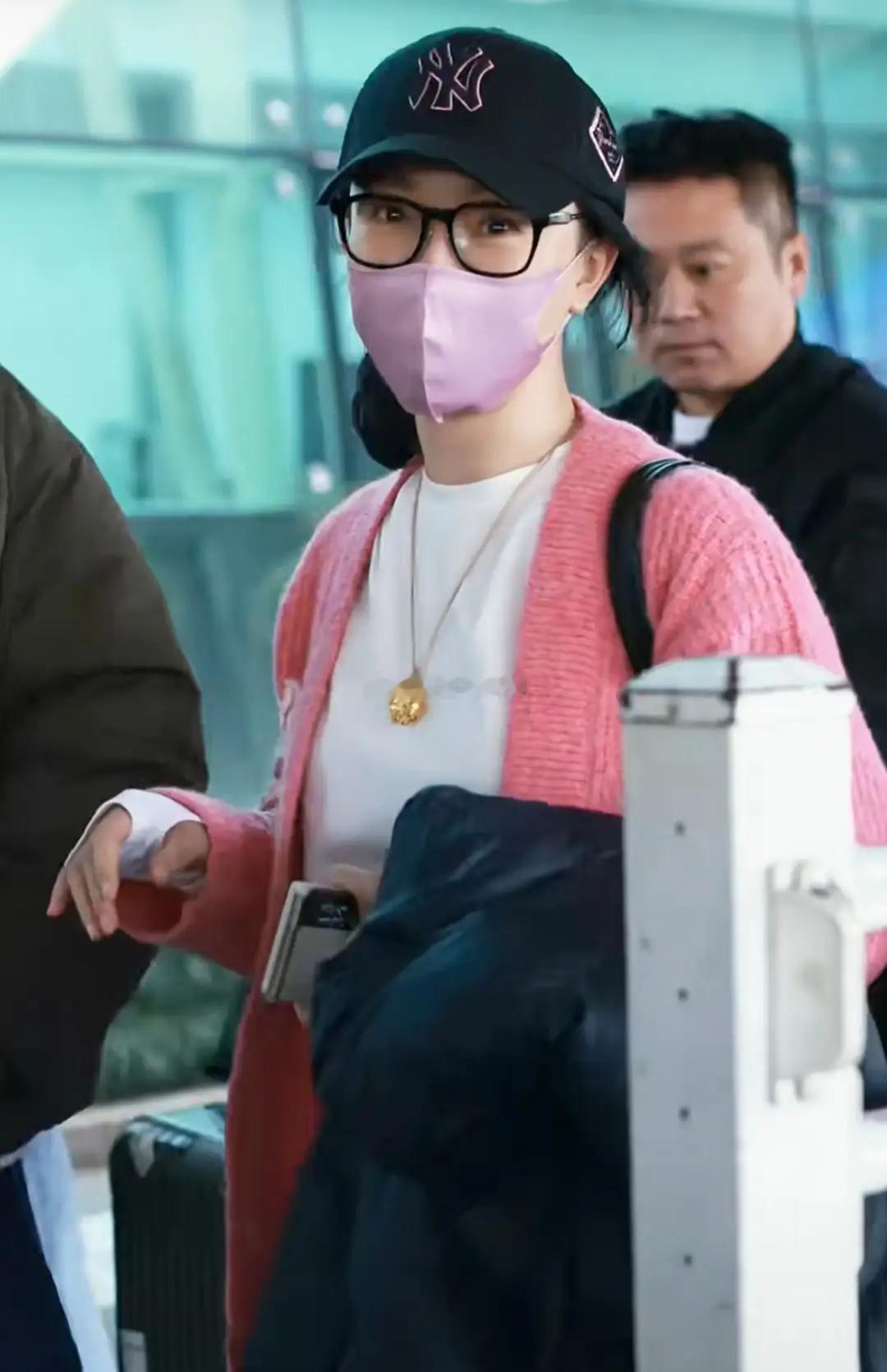 陈数身着桃粉色毛衣外套，配粉色口罩现身机场，粉嫩造型衬得她气色绝佳，美丽动人，一