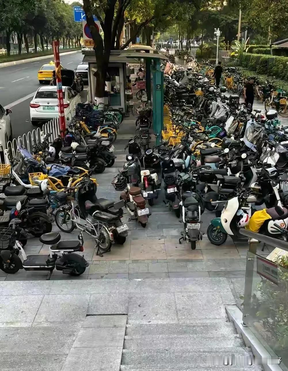 广州猎德地铁口附近停放的电鸡们，有些车甚至堆放到了天桥旁，几乎连通行的道路也快没