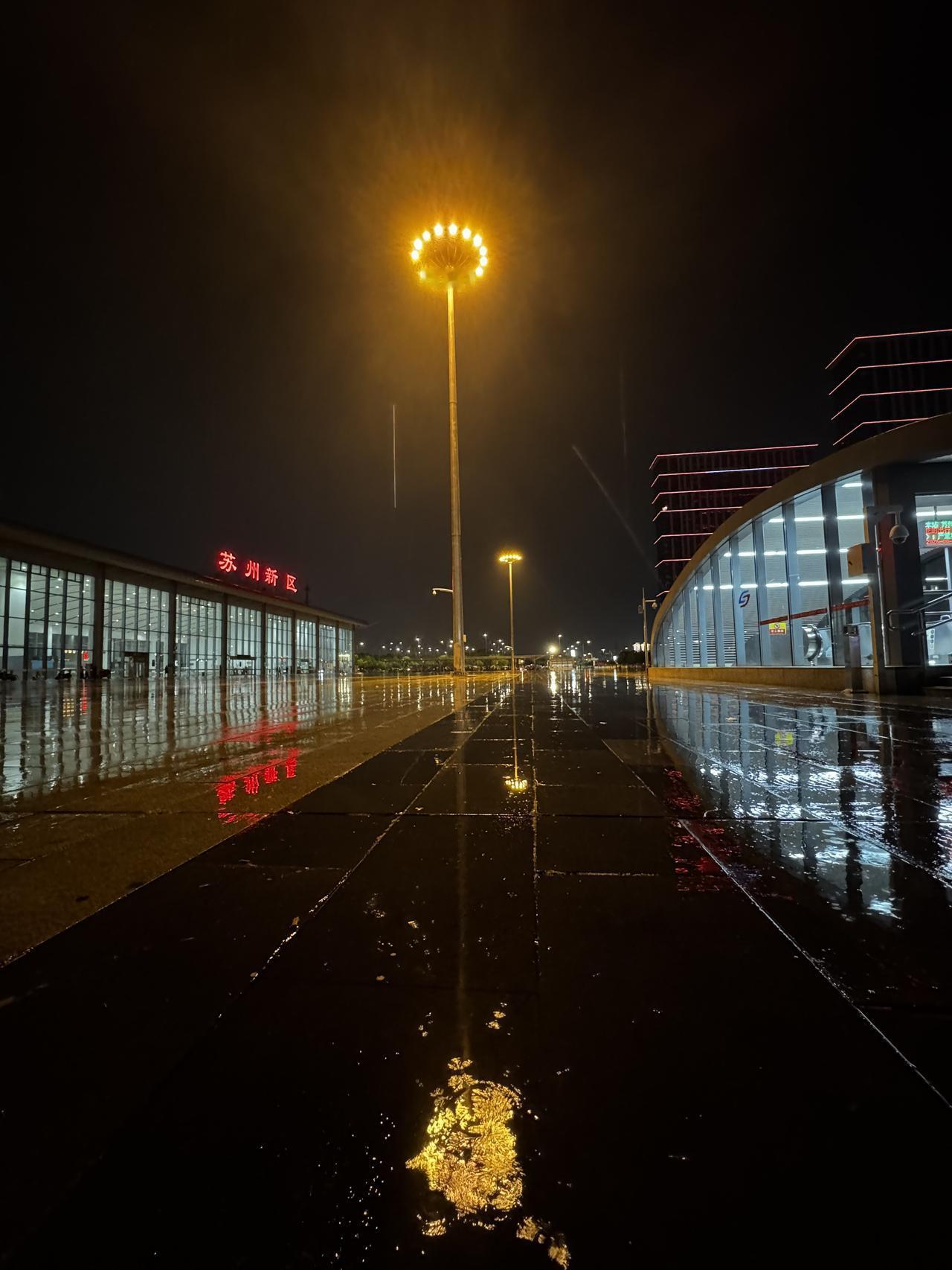 分享一张你最近随拍的照片这是一张非常有氛围感的夜景照片。画面中的“苏州新区”红色