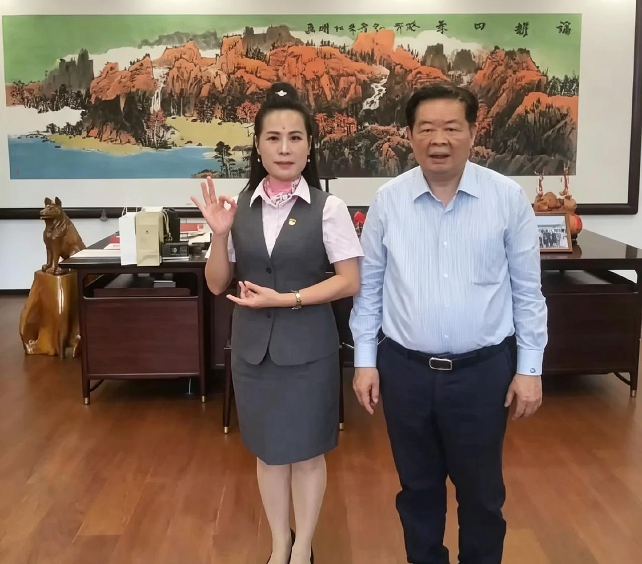 曹德旺办公室这张合影挺逗。老爷子穿件衬衫特随意，旁边女粉丝倒像在拍职业照，手还比