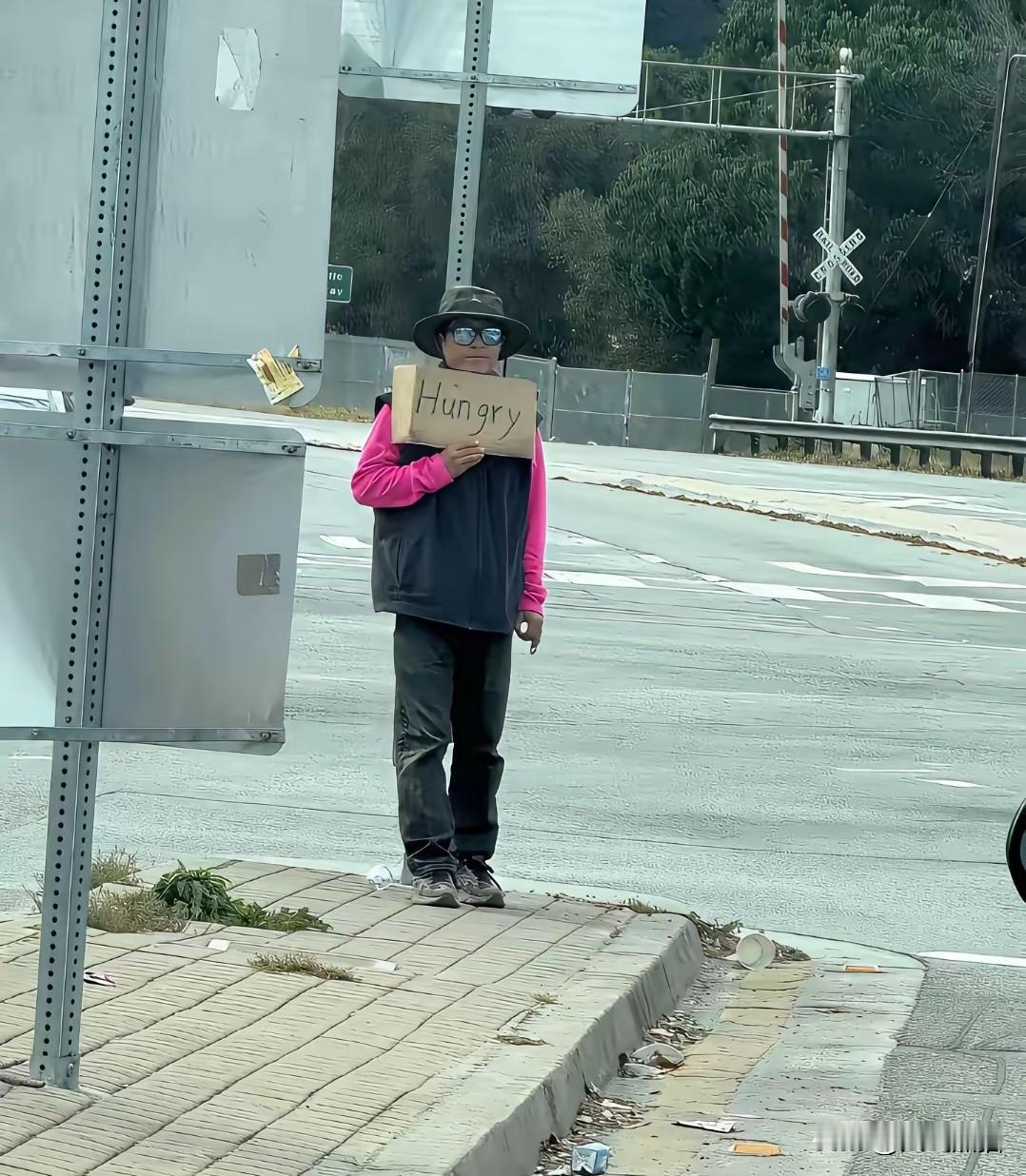 知名大殖子号称“甜甜圈”的王伟恒，如今在美国街头举起了牌子谋生，只见他站在街边用