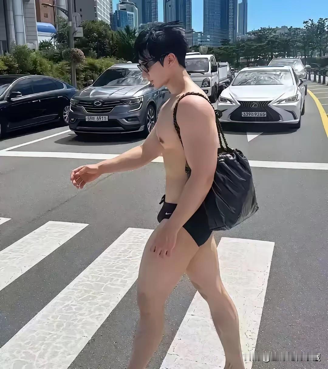 国外肌肉小哥玩的真花，居然敢于穿一条耐克三角泳裤、背着黑色背包在街头行走，还拍摄
