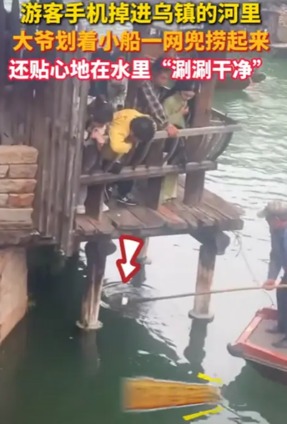 “笑不活了！”浙江乌镇，一女游客手机掉进乌镇的河里，大爷划着小船，用网兜给捞了起