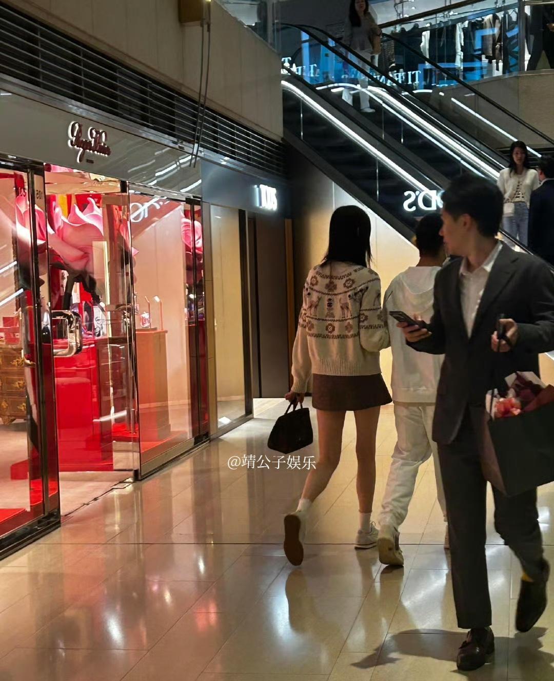 奚梦瑶挽着何猷君逛静安寺，短裙长腿，笑得像刚偷到糖的小孩。他矮墩墩的，手却攥得