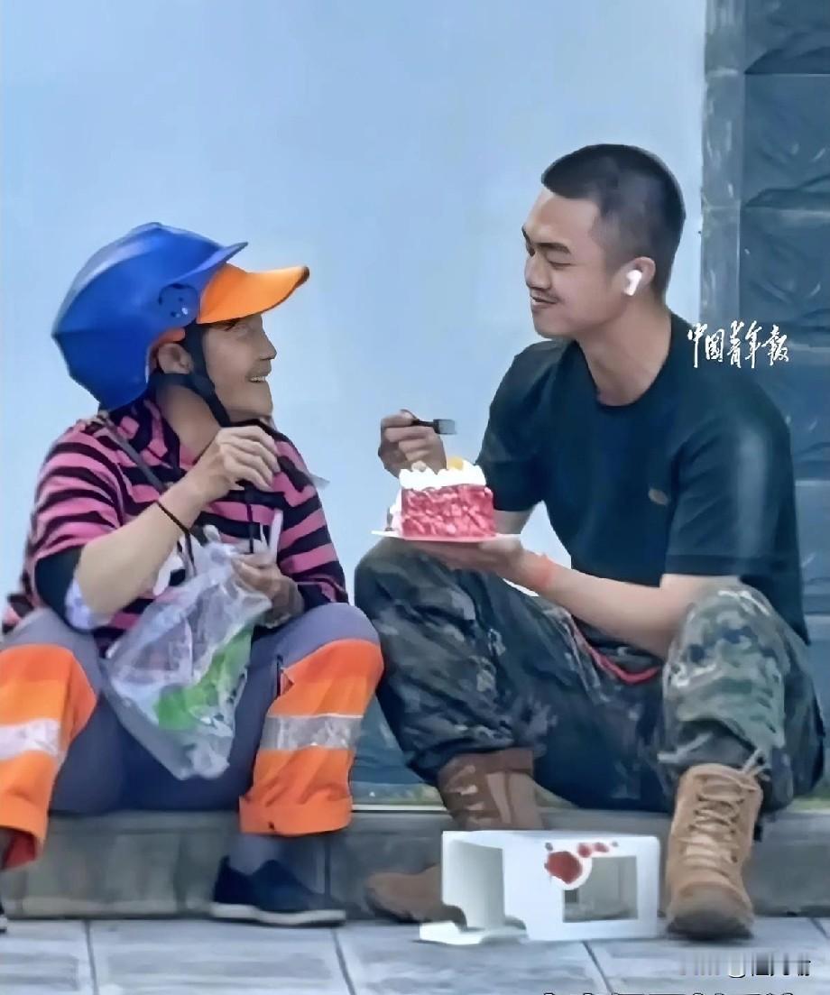 云南，新兵儿子即将入伍，环卫工妈妈带着小蛋糕前来送别，母子俩就坐在路边的石阶上，