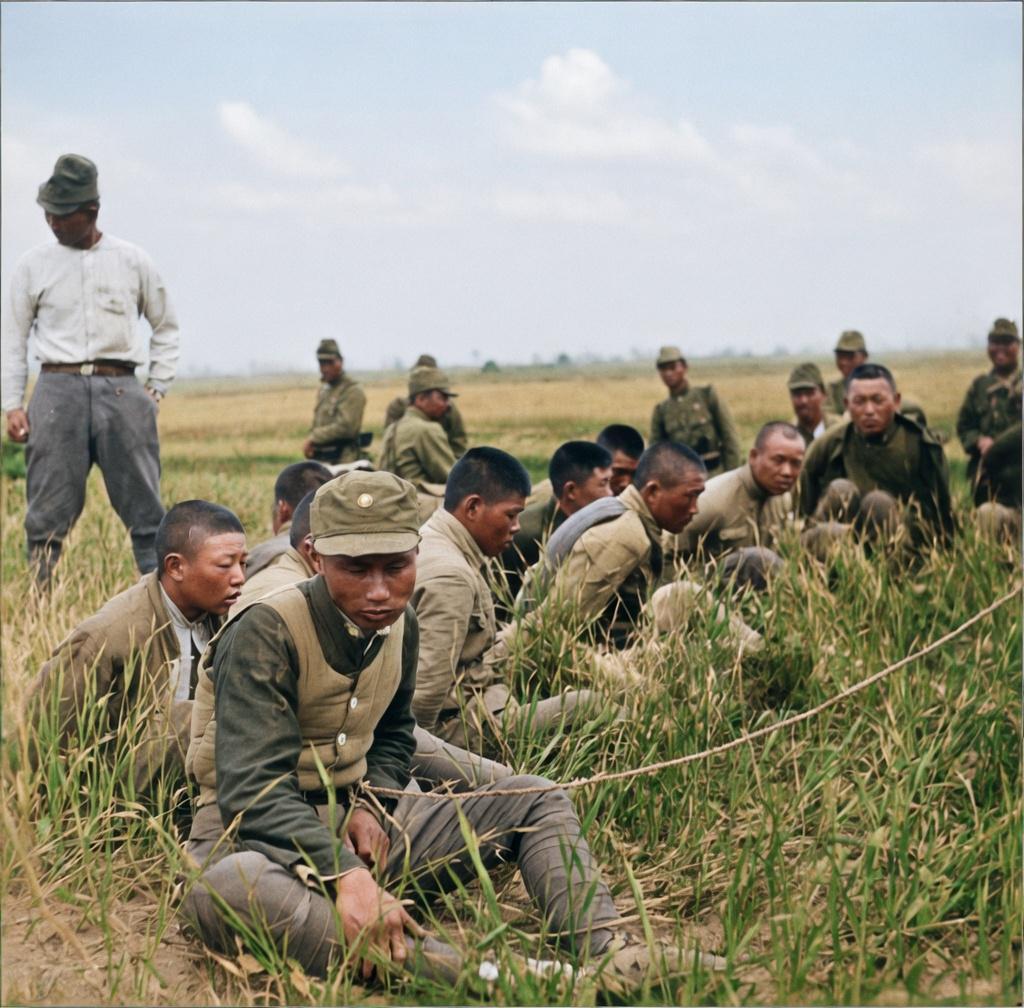 抗战时期，洛阳西工战俘营中，被俘中国士兵等待被日军处置的绝望场景。开阔的草坡上