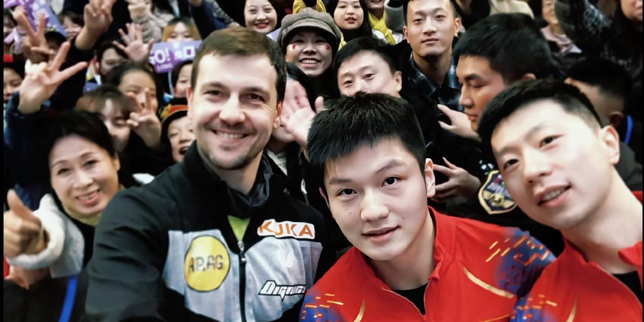 樊振东，慈眉善目，清秀帅气，身边有肯定支持自己的朋友和龙队，振东不语，只是一味眼
