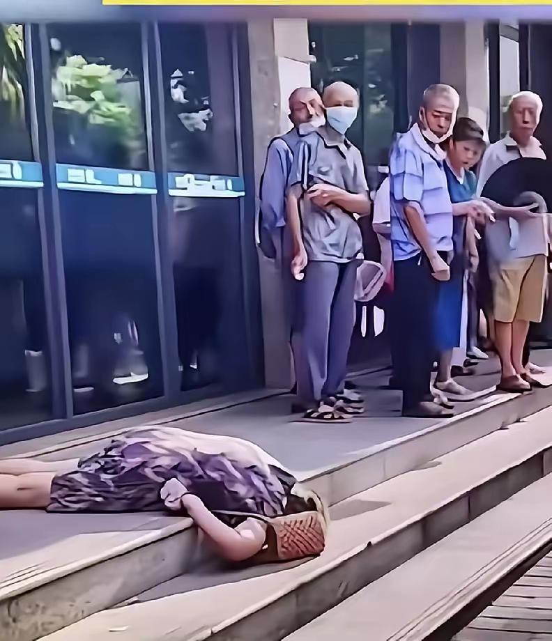 这位老人面朝下，肯定是摔得很惨但门口那么多人都指指点点，议论不休：扶不扶不扶