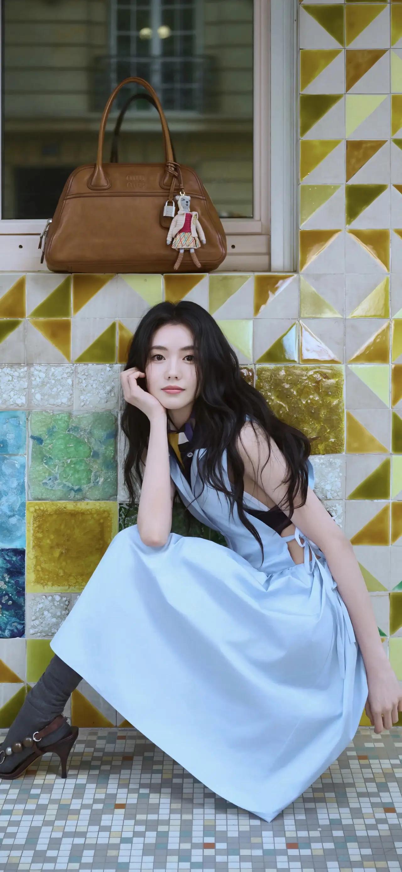 美女壁纸～刘浩存，浅蓝裙摆漫过街角的彩色花砖，复古棕包载着细碎的日常。耳机里的旋