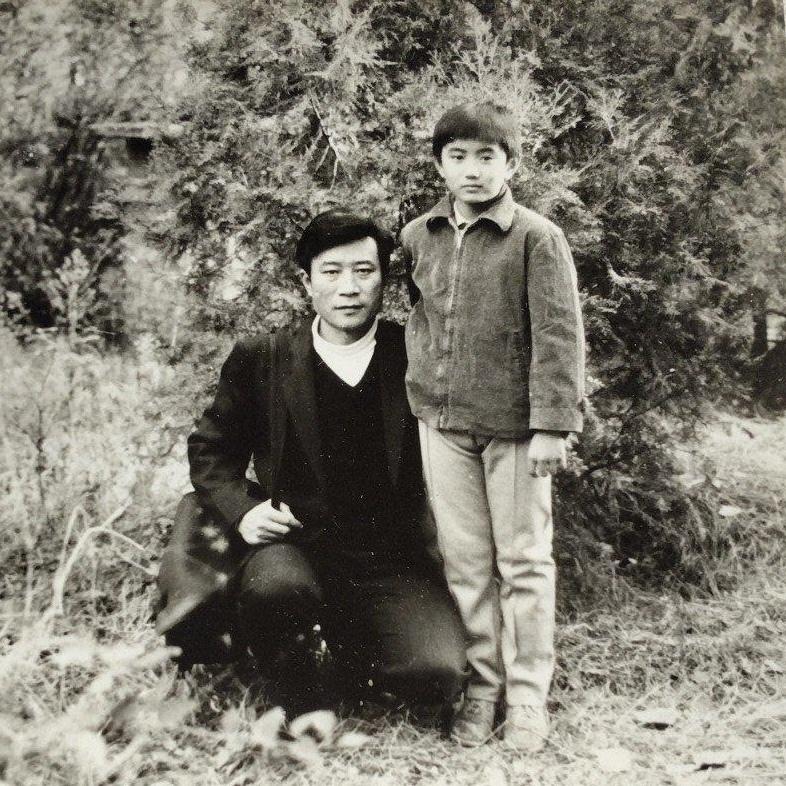 90年代，童星叶静和李雪健，一张罕见的合影，镜头中的李雪健穿着西装，蹲在地上看起