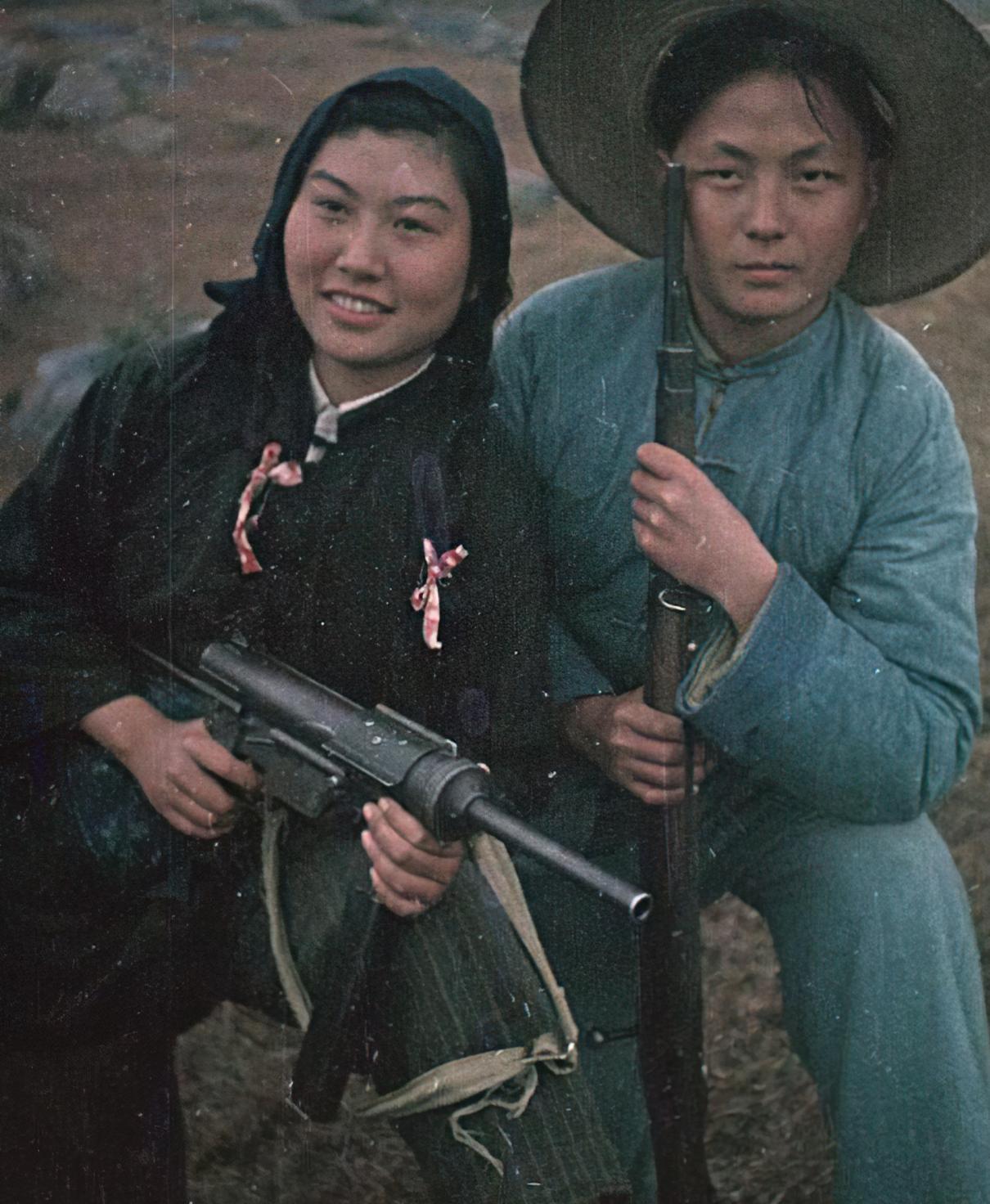 这是解放战争时期的游击队女兵，扎了两个马尾辫，还系了两个花蝴蝶结，一边端着美式冲