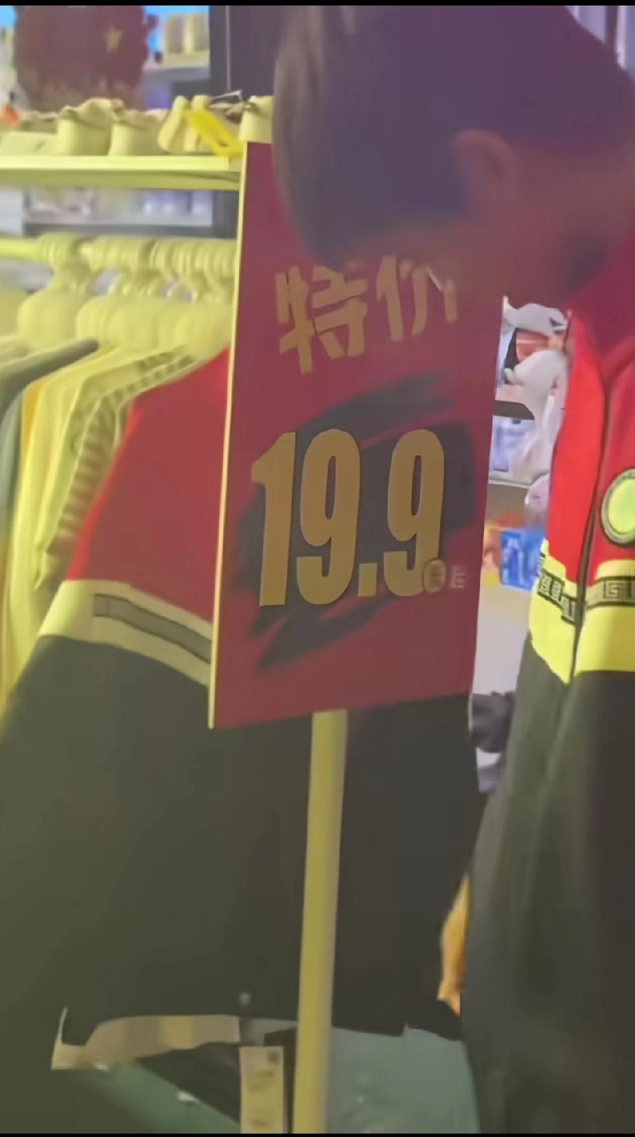 小学生穿着校服去逛商场,看见子件和自己穿的一模一样的衣服,翻了又翻,看到上面标价