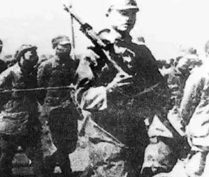 1942年，在日军海州战俘营里，5个看守日军正在喝酒吃肉，角落里一名躺在地上的八