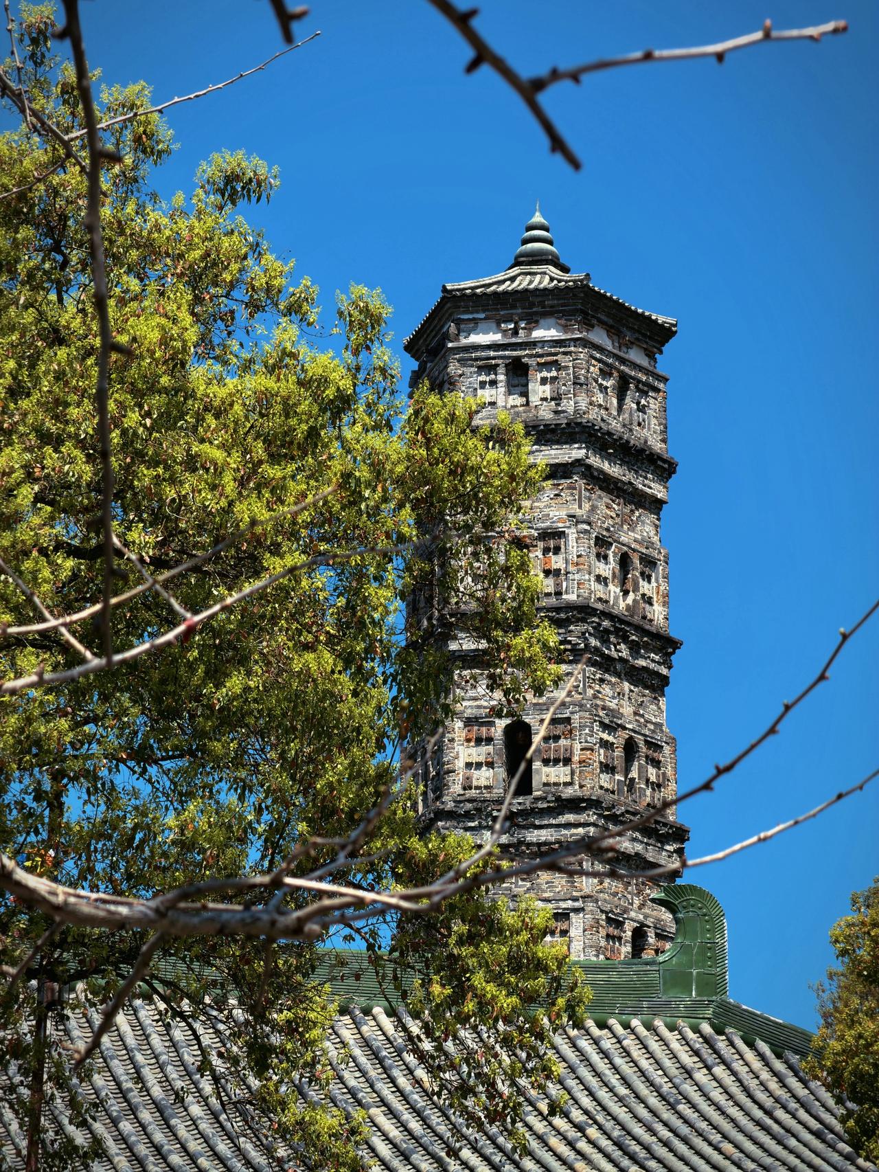 春日古镇，晴日正好。新绿爬满枝头，青瓦接住阳光，远山在风里安静。在这里，连风
