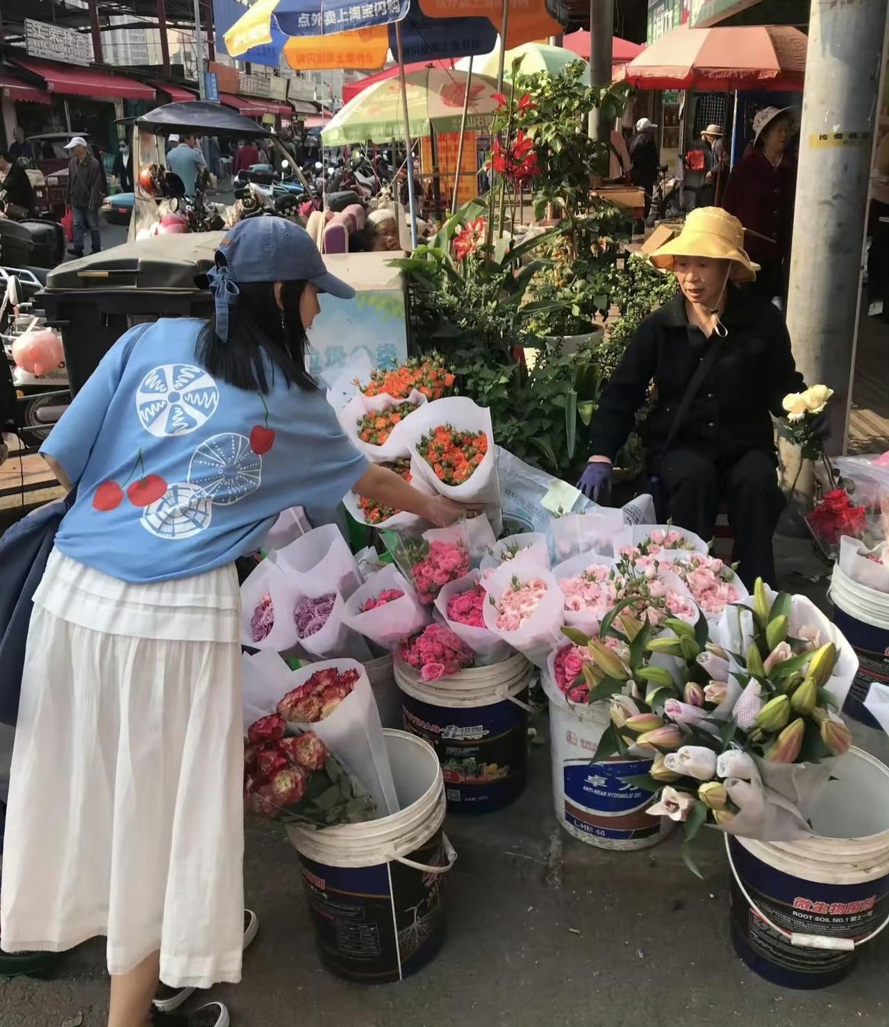 46岁的董洁在云南逛菜市场时被网友偶遇。她身穿一袭白色连衣裙，搭配简约而时尚的配