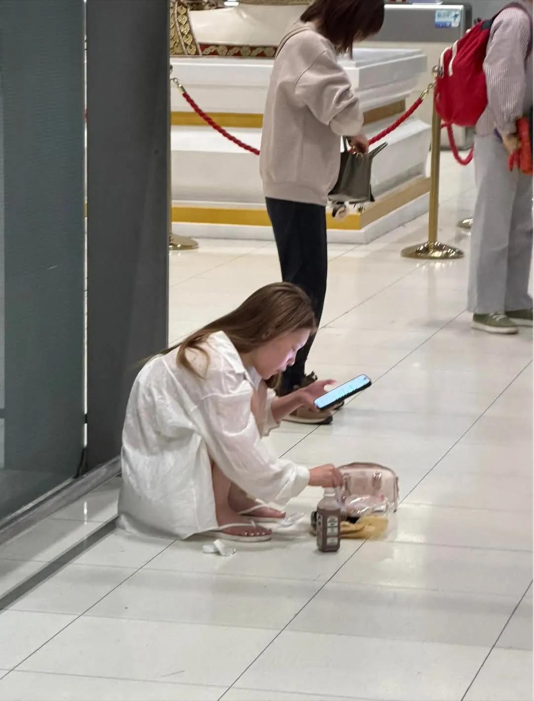 先是有香港网友发帖，拍到在曼谷机场里一个女生蹲在地上吃炒面，边吃边玩手机。发帖人
