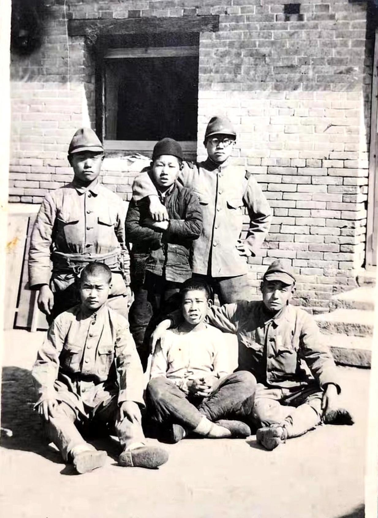 这是一张令人心疼的照片，4个日军士兵抓住了2个中国少年。日军把他们拉来照相，用来