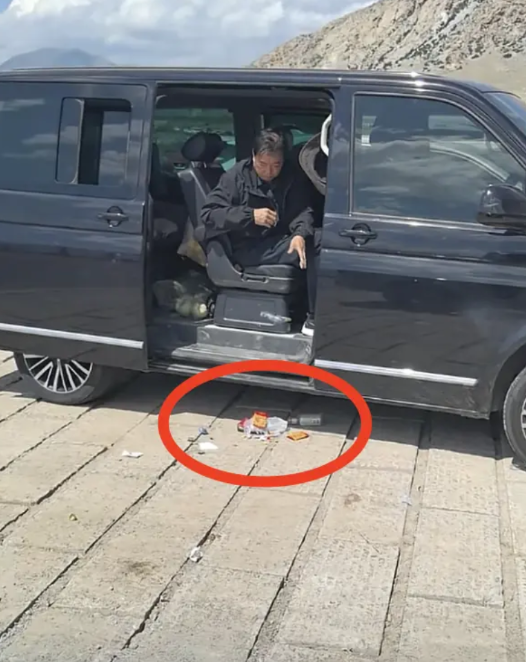 网友在新疆旅游时拍下的一幕：在新疆某旅游景区的停车场，一位中年男子在清理车上的垃