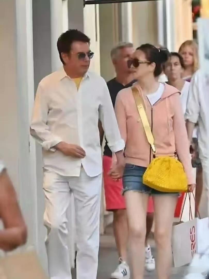 确实让人羡慕，巩俐真是被法国老公宠成小公主，两人全程手牵手一起逛街，巩俐穿着橘粉