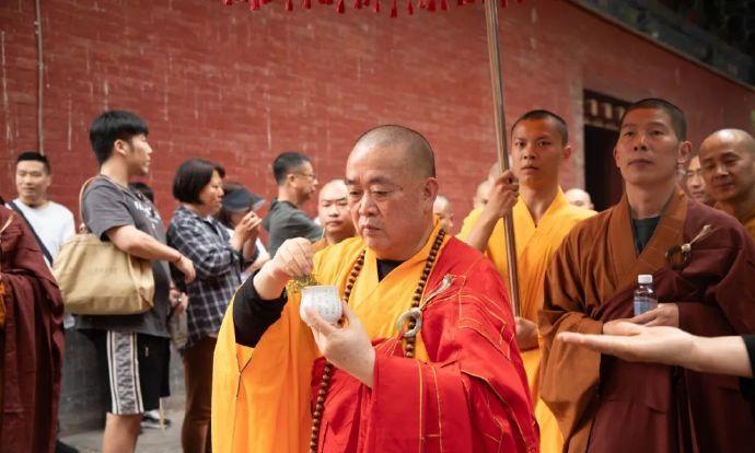 这是今年母亲节这一天中的少林寺前方丈释永信。释永信身披袈裟，带领着众弟子举行法会