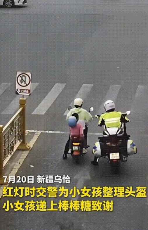 好暖！新疆乌恰，妈妈骑着电动车带着小女孩在路口等红绿灯，一辆交警停在了旁边，双腿