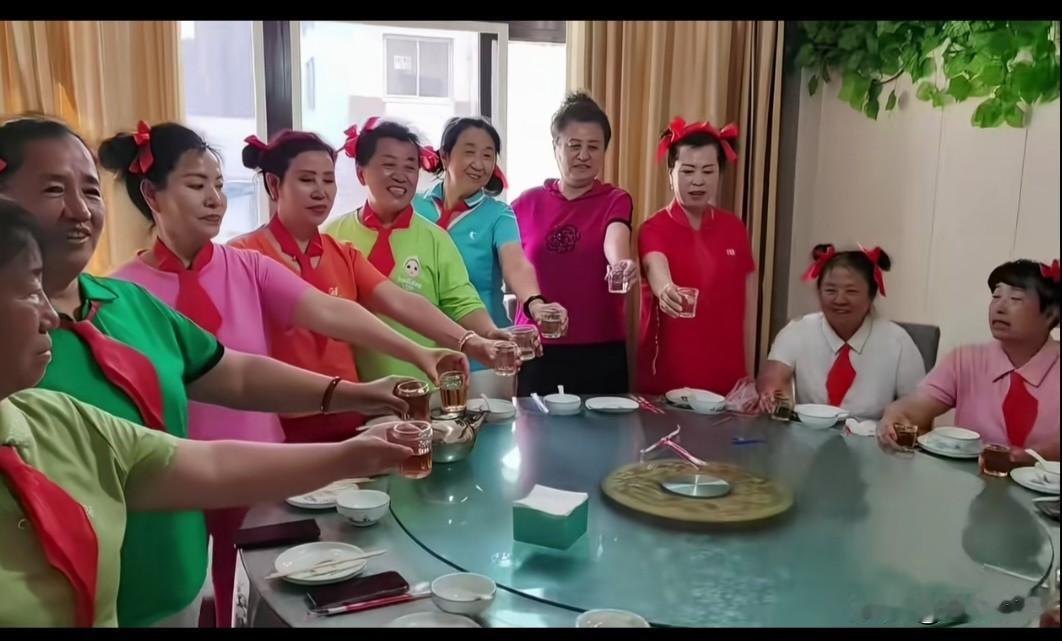 一帮退休大妈戴着红领巾，打扮成小学生模样聚餐，这场景还挺有争议。像在武汉中山公
