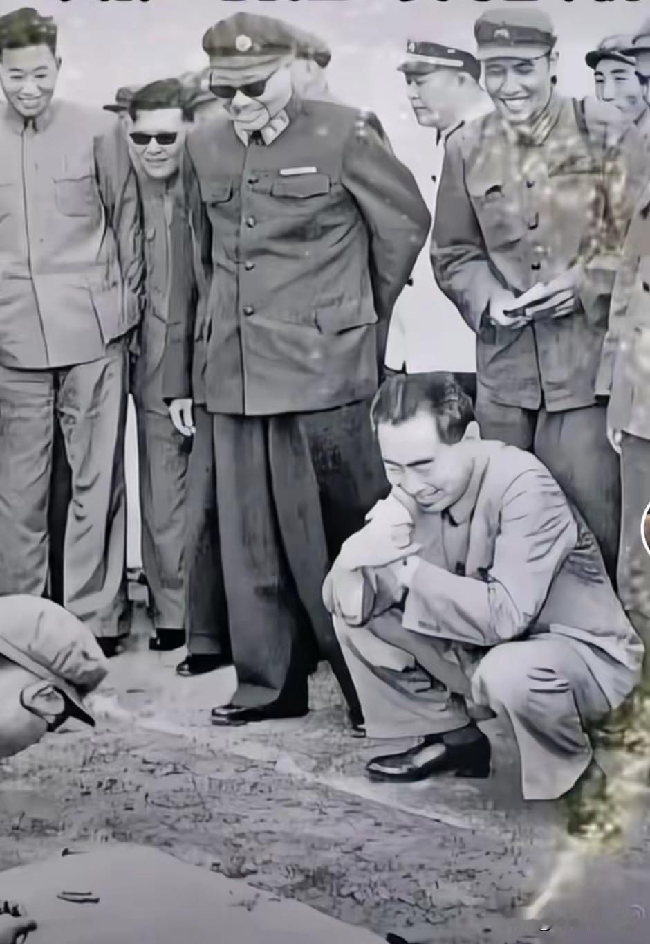 1964年南京大比武现场，周总理蹲身细看战士枪械实操，贺龙元帅一同视察，没有架子