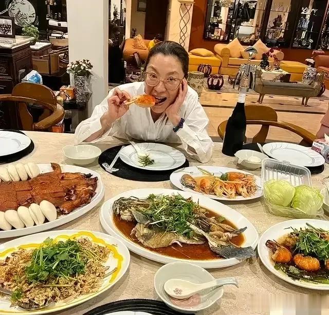 照片上是女星杨紫琼在家吃大餐的情景。桌子上的菜真多，都是荤菜，名副其实的大餐啊