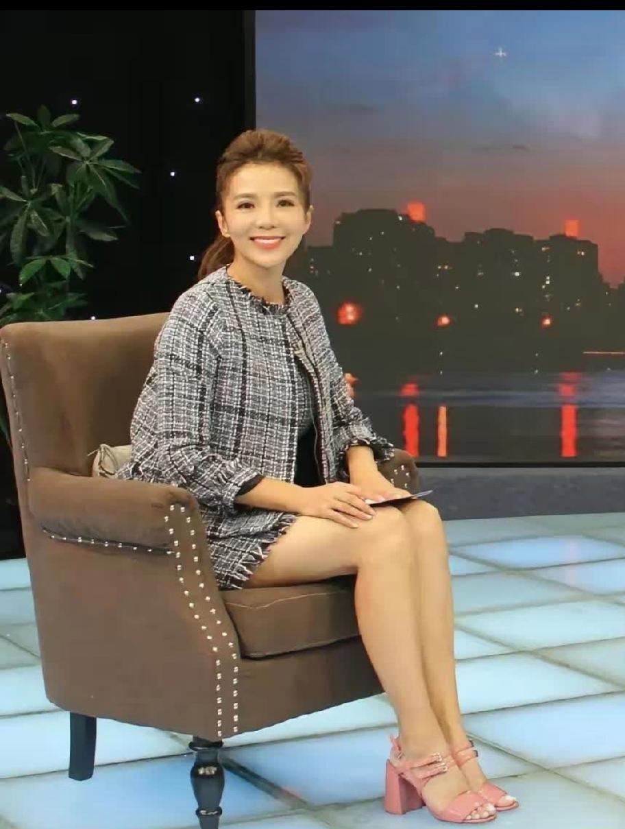 坐在椅子上的她，脚穿粉红色高跟凉鞋，两脚拼拢，双膝微屈，侧身笑对镜头，这天生丽质