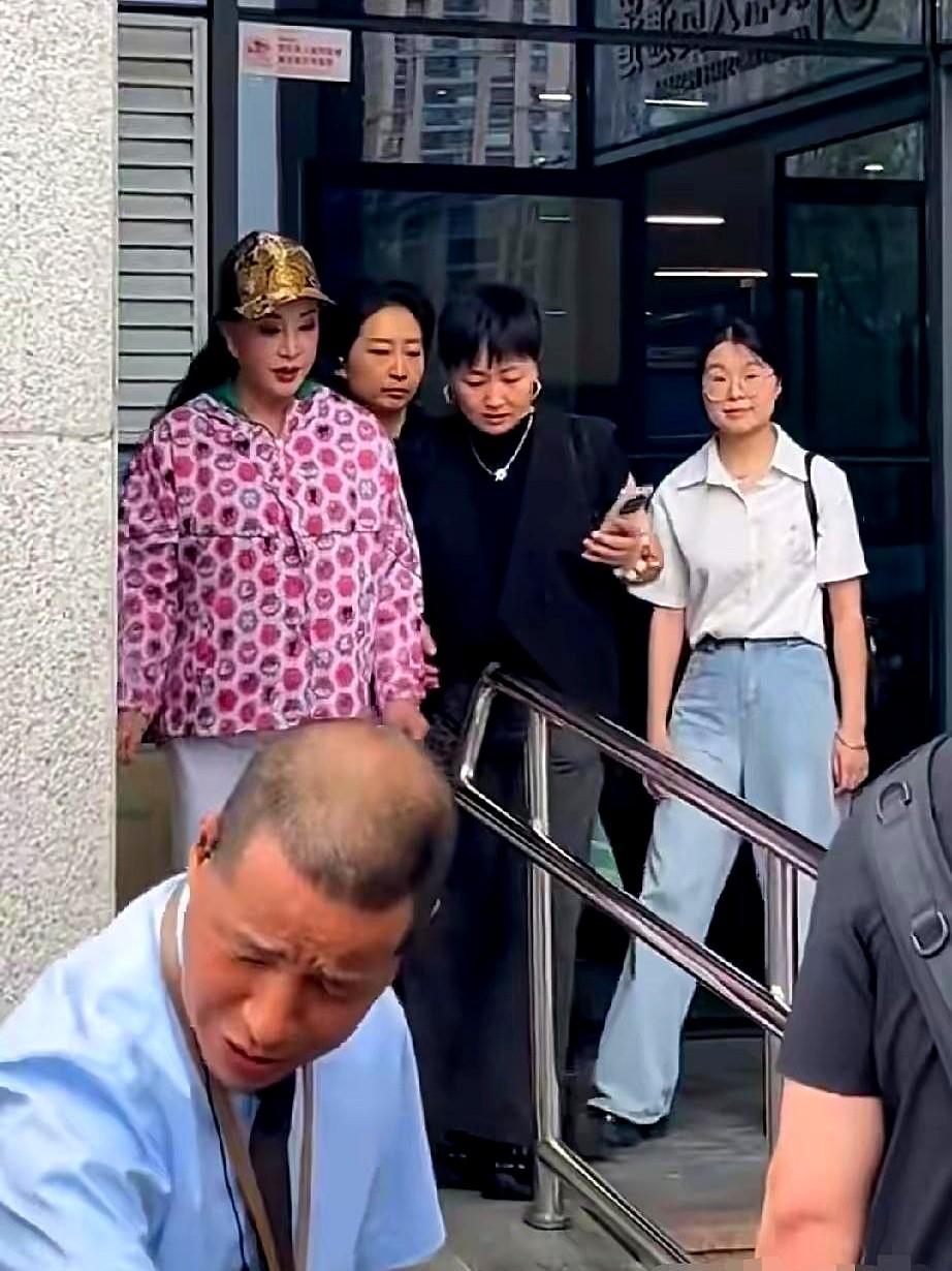 重庆街头，刘晓庆头戴大红花，手里还捏着根红辣椒，旁边人一直搀着她。大热天里，