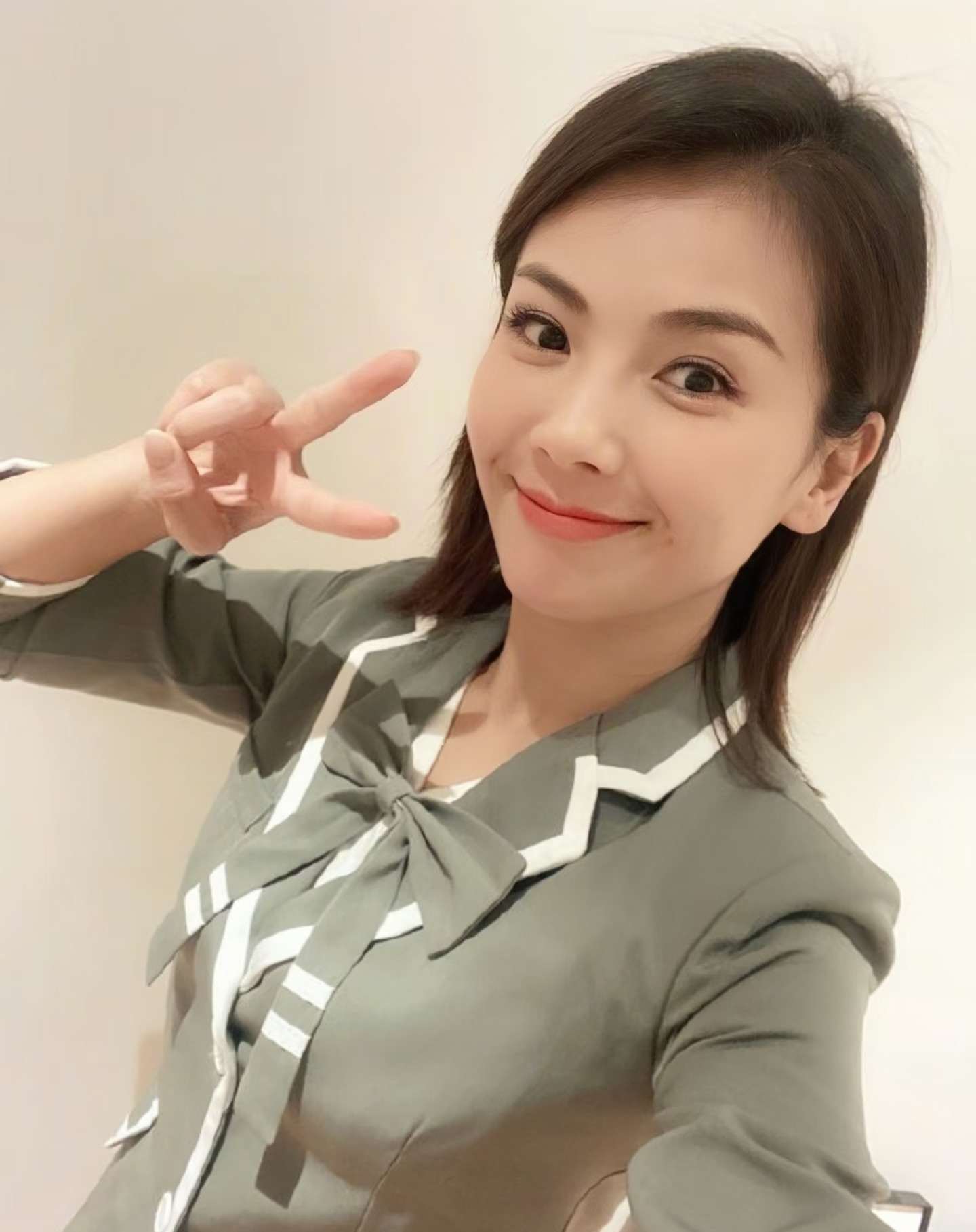 刘涛一身灰调学院套装蝴蝶结配百褶短裙，清爽又减龄。妆容干净柔和。镜头前大方摆姿势，比耶、俏皮眨眼，神