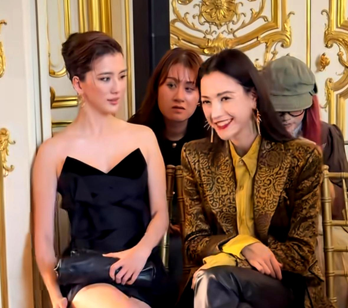 巴黎时装周看秀现场，赌王千金何超莲跟女星娜然同框拍照，身高一米七多的娜然全程主动曲着腿，硬生生把自己