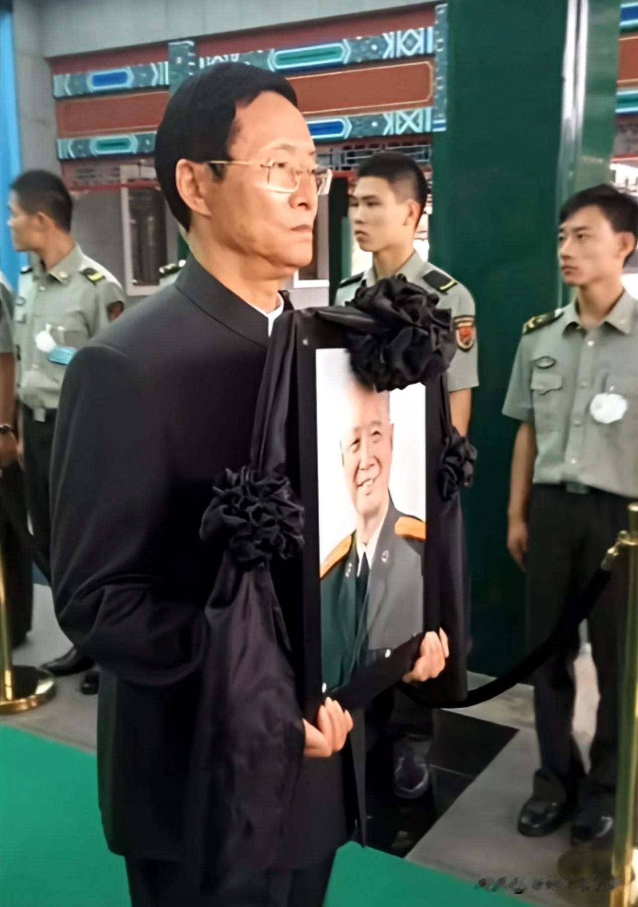2015年9月9日，张震将军遗体送别仪式现场肃穆沉重。儿子张小阳身着深色正装，双