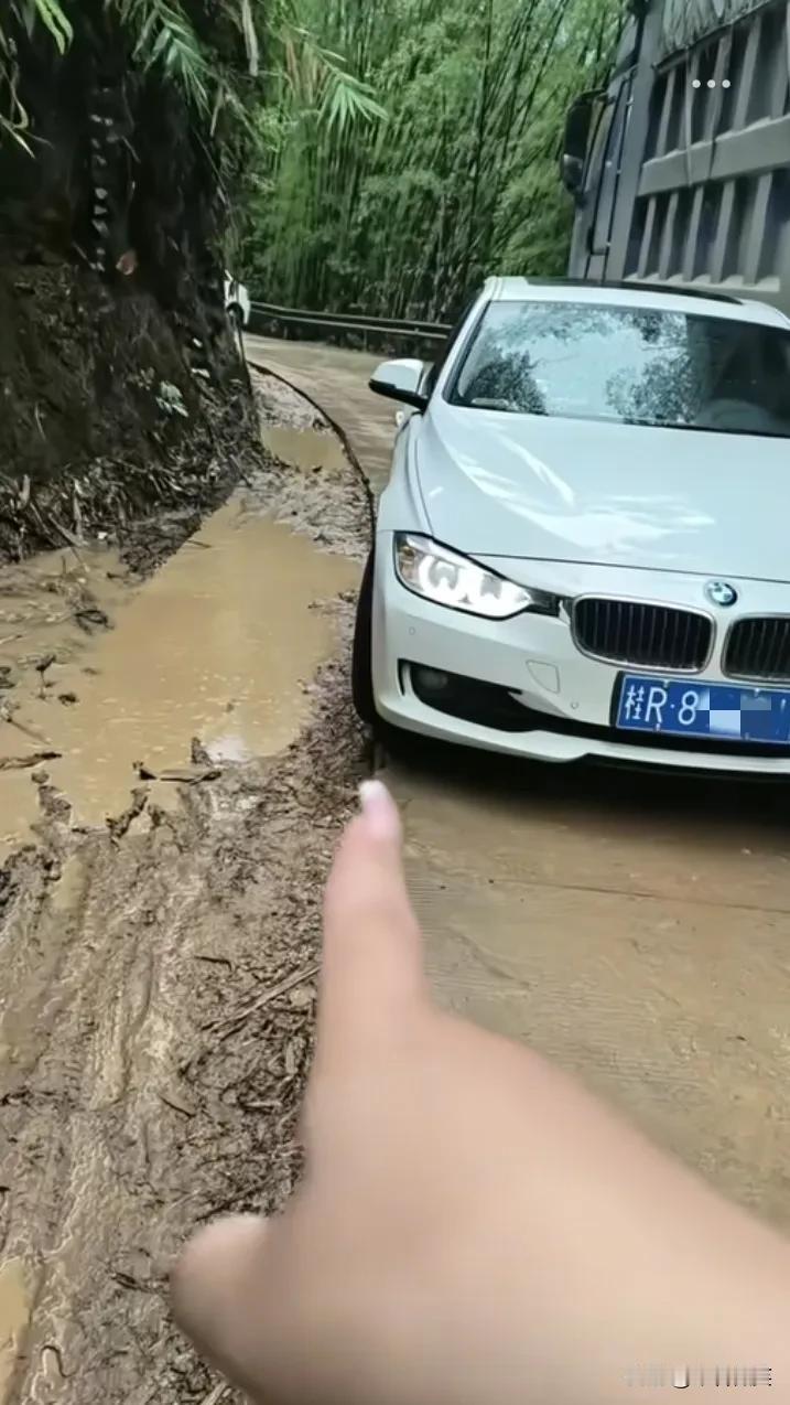 广西一山路，小车与大货车会车，宝马女司机爱惜自己的车，没有往泥巴路里开，导致大货
