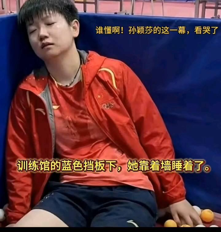 谁懂？孙颖莎的这一幕看哭了。训练馆的蓝色挡板下，她靠着墙睡着了。汗水把队服浸得
