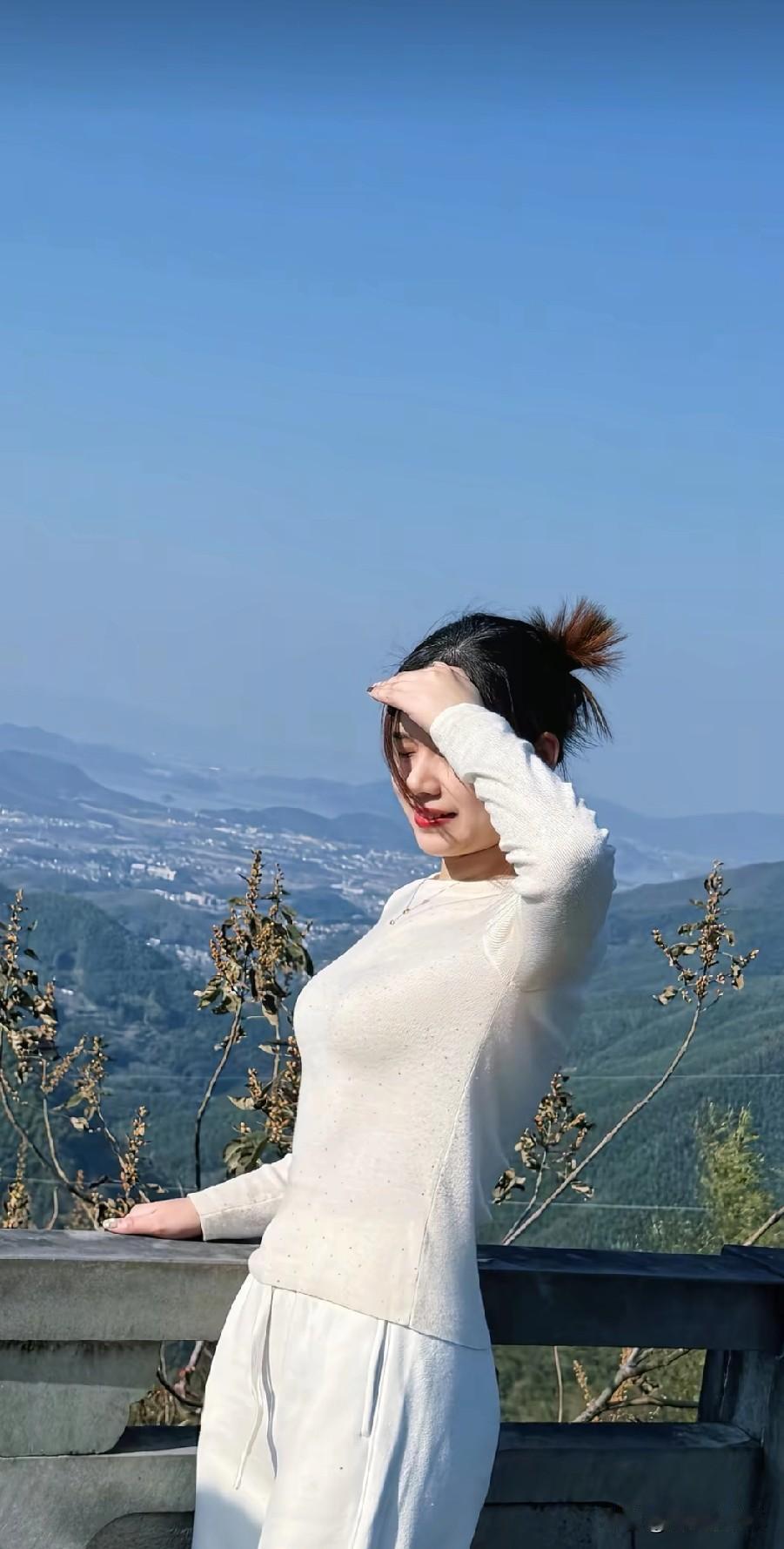 山顶上的白衣少女，享受着阳光与微风