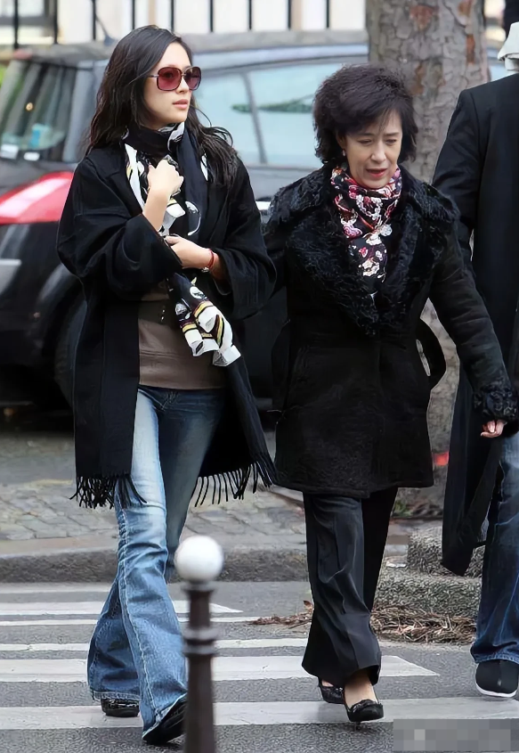 没想到章子怡的妈妈这么时髦，母女俩一块过斑马线，她妈妈嘴里好像一直在嘱咐女儿，章