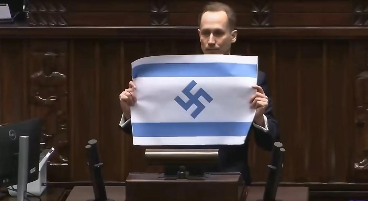 波兰议员贝尔科维奇在波兰议会向在座的议员们展示了一张印有以色列国旗的纸，而在以色