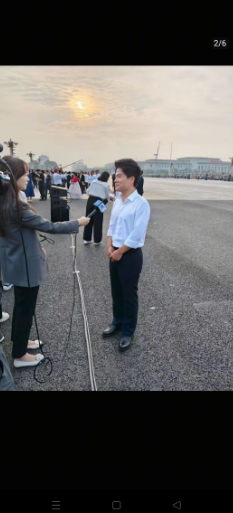 董宇辉在天安门接受新华社张扬访问现场的他，白衬衫黑西裤皮鞋，一如既往的简单清