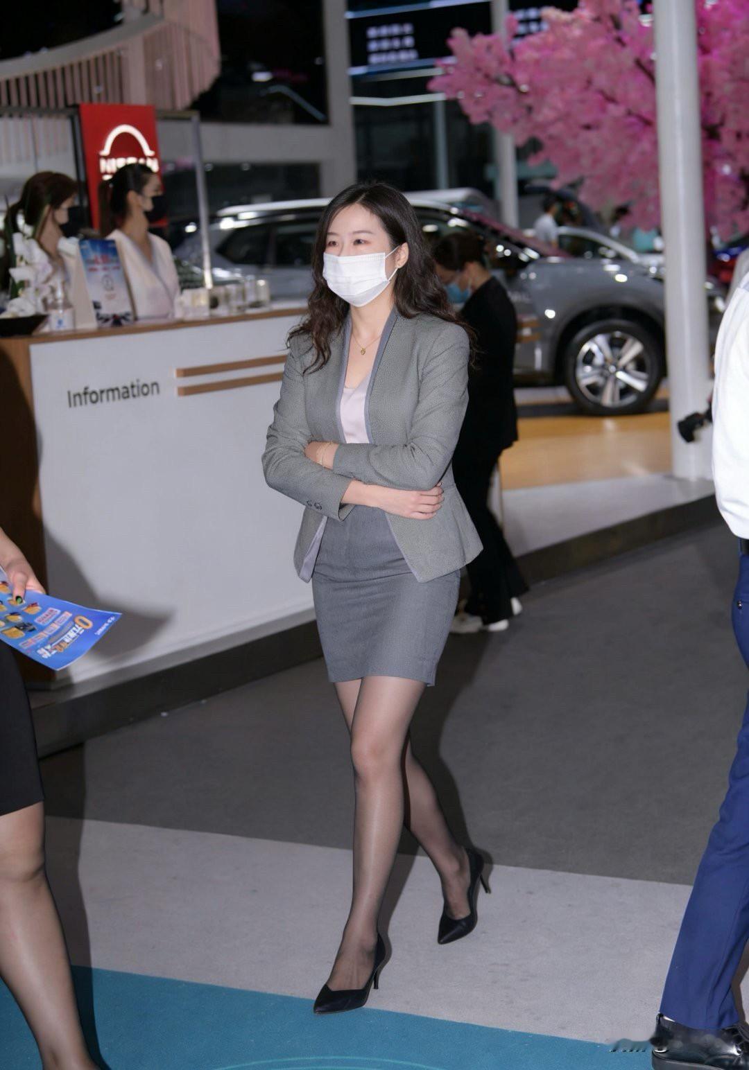 职场美女手拿资料，自信满满，雨伞相伴，尽显优雅风范！