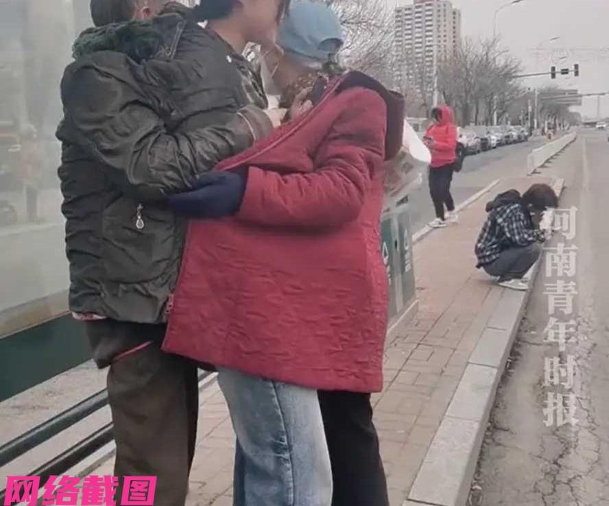 天津有女孩在公交站等候公交，但天冷女孩穿着又少，有点被冻得浑身颤抖起来。此刻