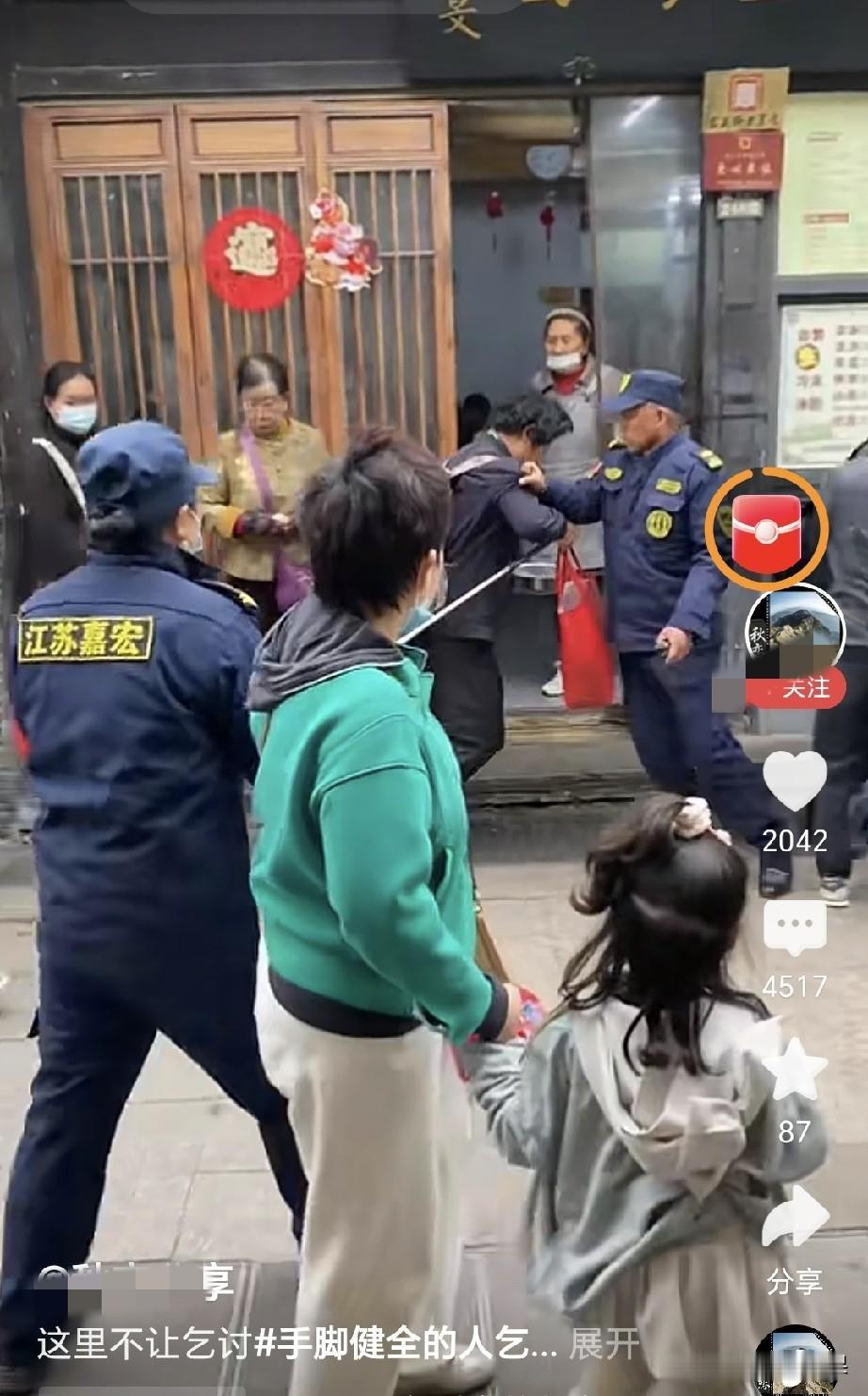 一位年轻小伙到扬州关东街乞讨被保安拦阻，他背个包胸前挂着收款二维码，手里拿着了不