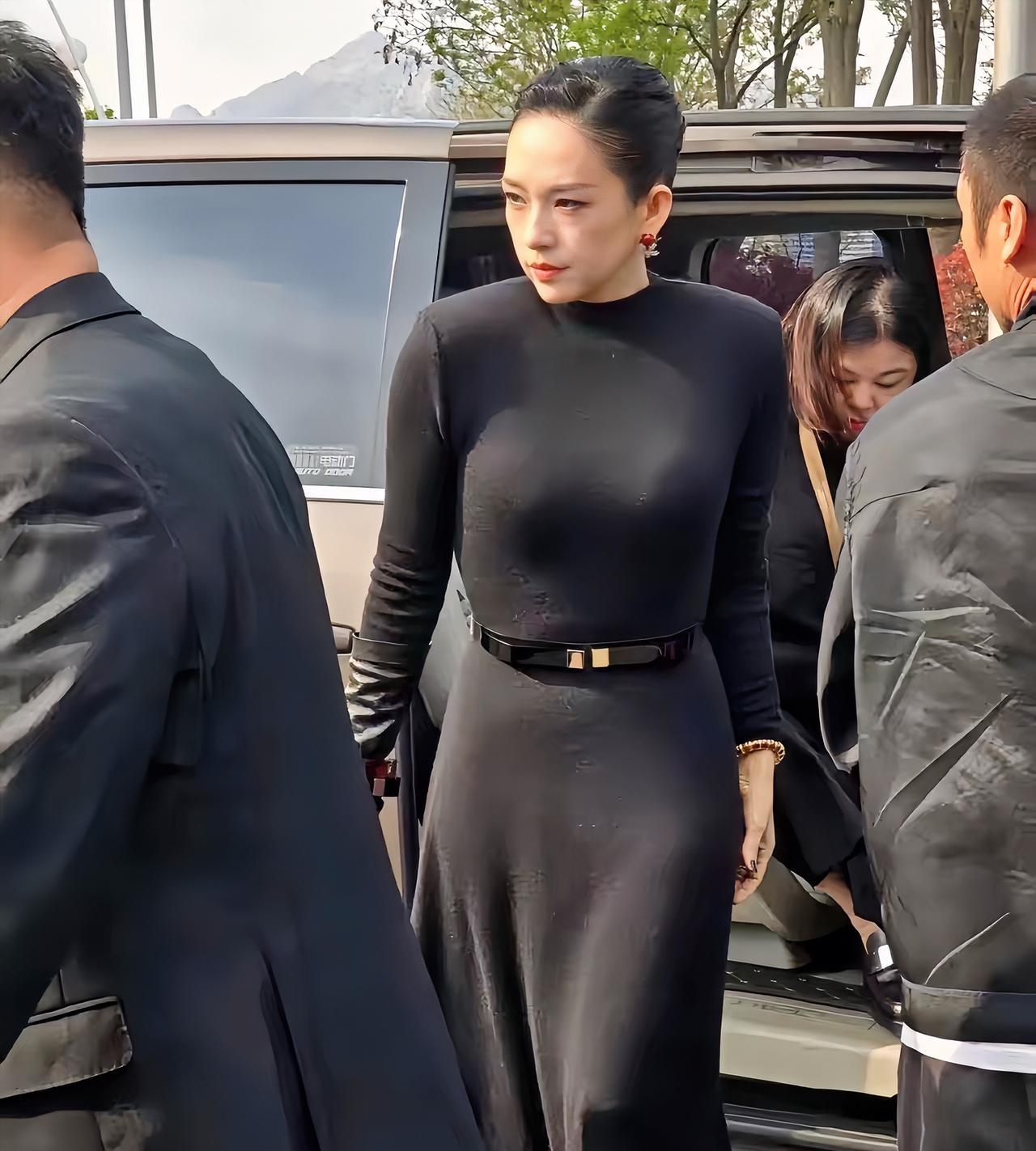 章子怡近照，去青岛参加华表奖时的造型，一身黑色束腰连衣裙，挽着头发，眼神犀利，气