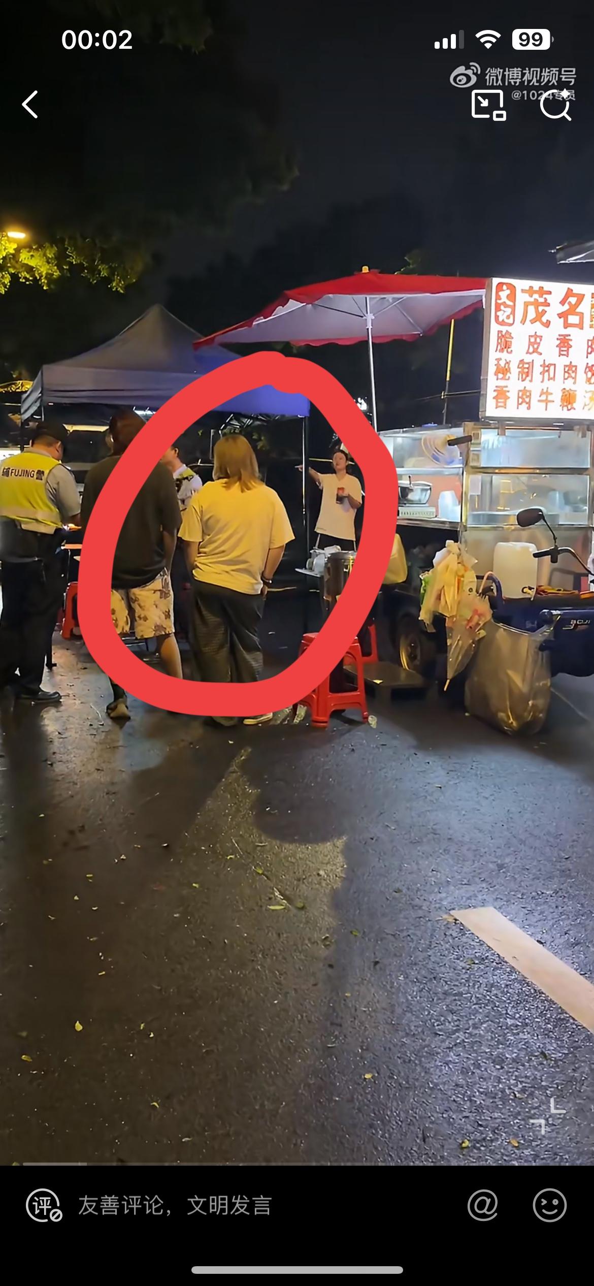 一个摆摊卖香肉，也就是狗肉的档主，被图中的黄毛女子给报警举报了，帽子叔叔也赶到了