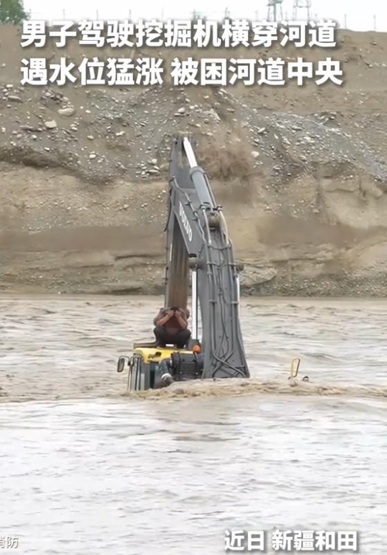 近日，新疆多地遭遇暴雨袭击。新疆和田，一名男子驾驶挖掘机横穿河道时，突然水位