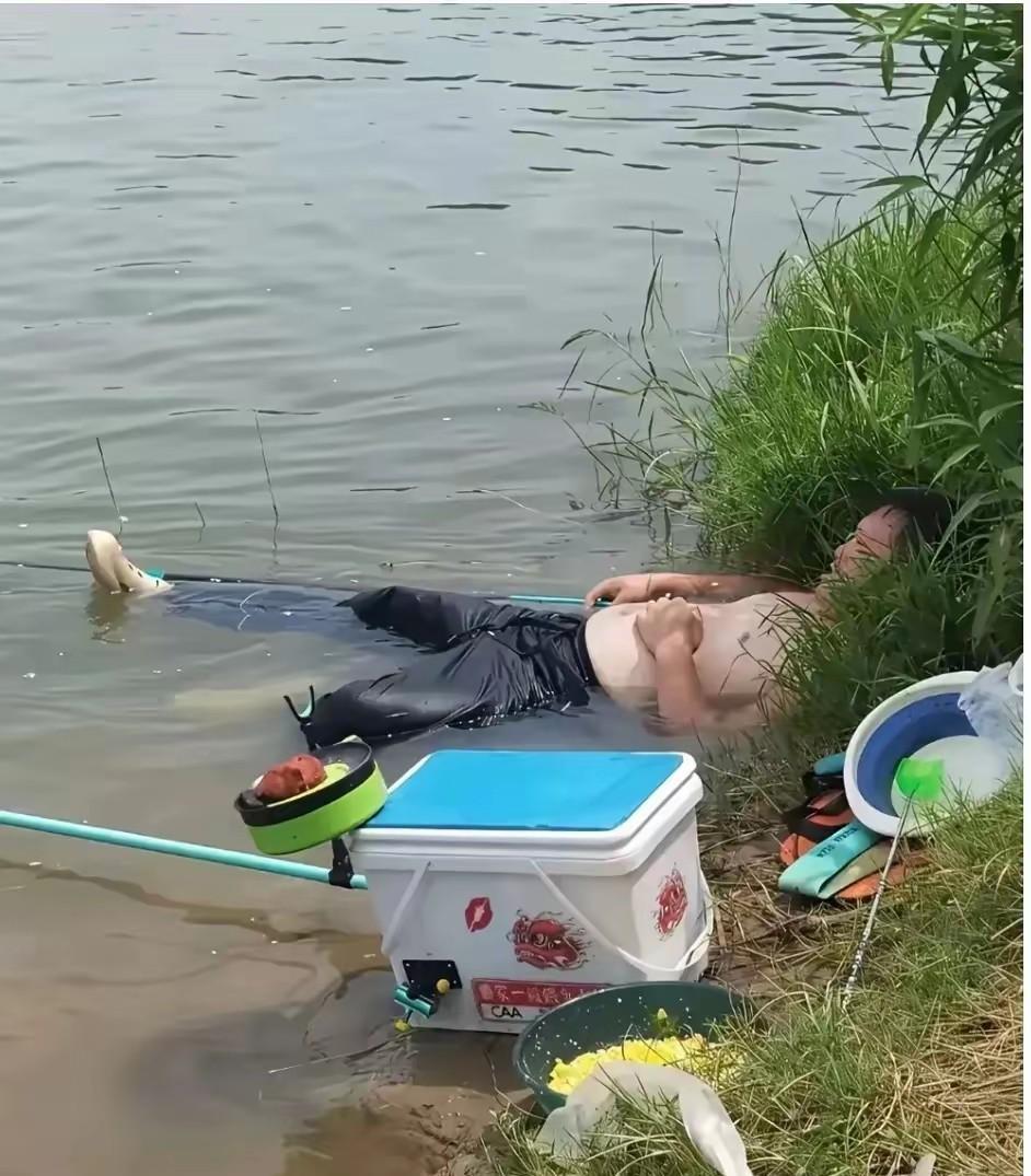 这哥们钓鱼钓累了，也应该是热的受不了吧，直接充分利用现场的环境，把自己泡在了水里