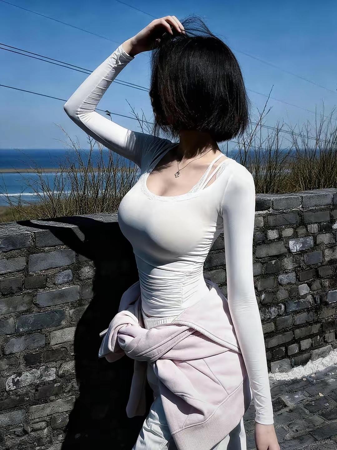 《海隅风致》短发轻扬趁晓风，素衣裁得玉玲珑。凭栏一任潮声远，心与沧溟共