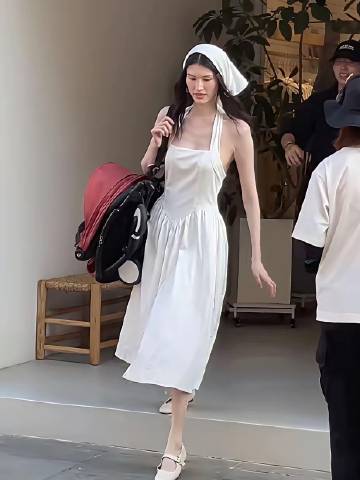何穗身穿一身白推着婴儿车，也许是要营造出油画田园少女风吧，头上还搭配着...