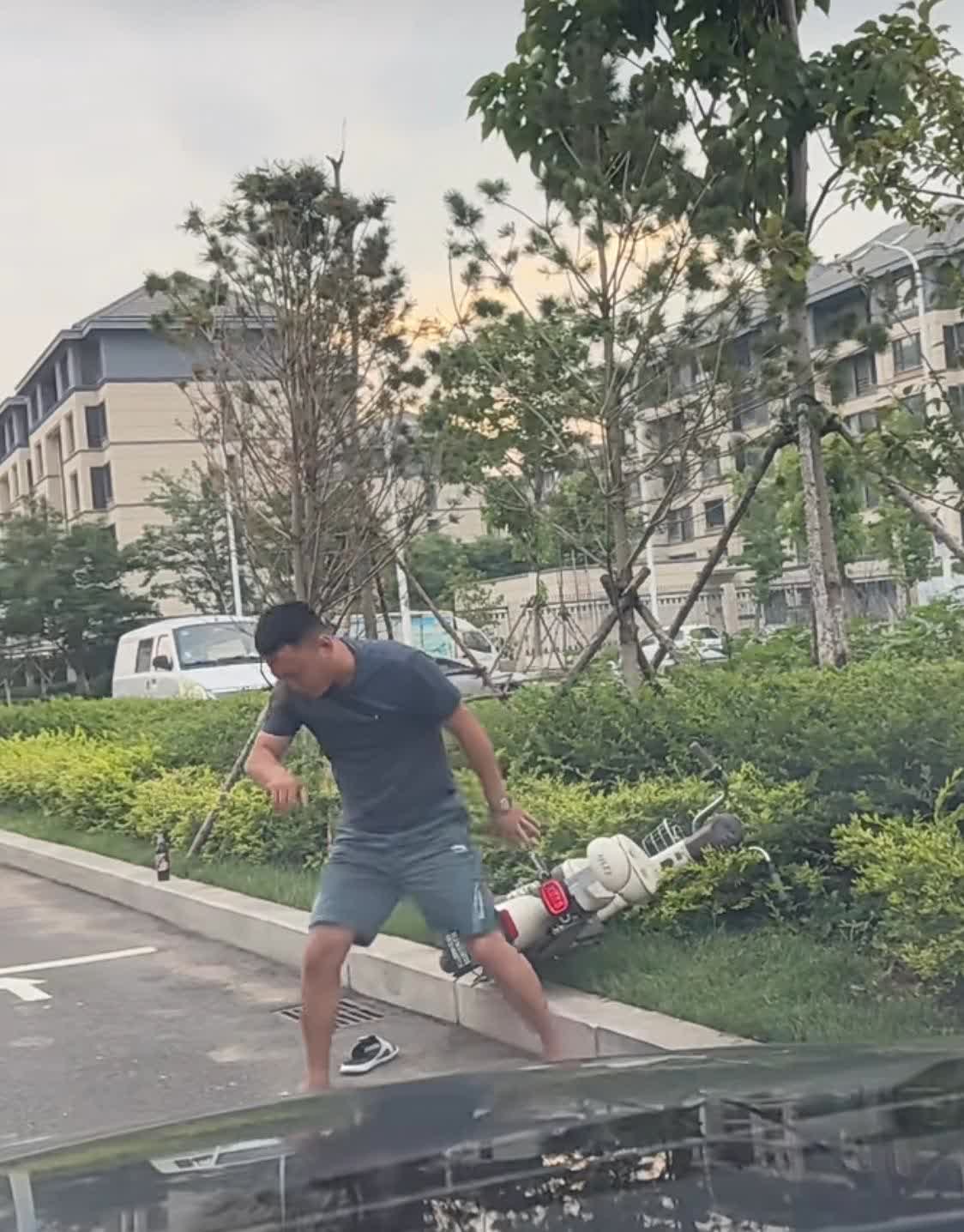 看到一段视频，男子骑着摩托被一人撞飞在绿化带，男子从地上艰难地爬起，冲着车大喊：